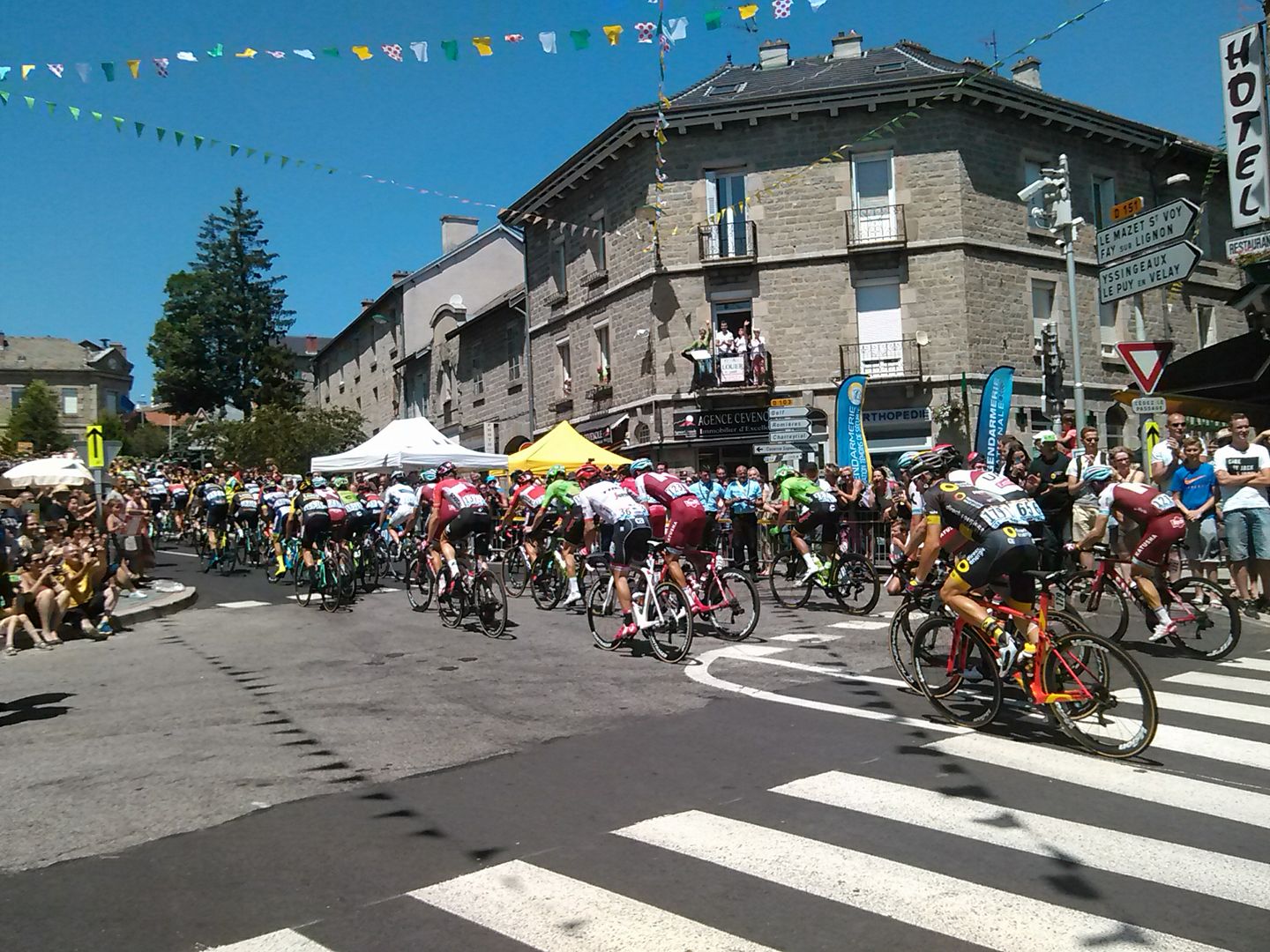 Le peleton du tour de France vire à droite à un carredour en ville